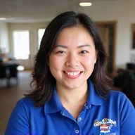 Portrait of Emily Chen, a friendly female manifest coordinator smiling in an office setting.