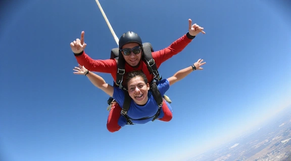 Skydiver performing a stable freefall arch with two instructors beside them.