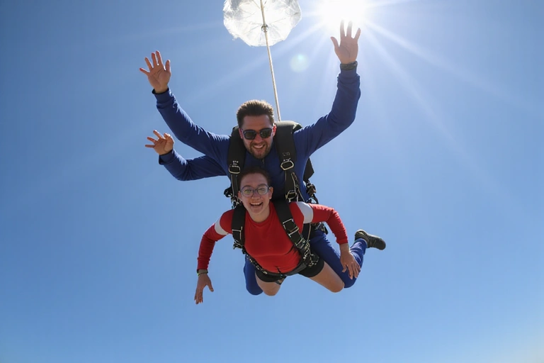 Skydiver practicing body position in freefall, with an instructor nearby.